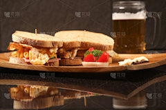 三明治放在木盘子里，桌上放着啤酒