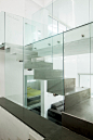 The home's central staircase is an interesting design focal point. Encased in glass and made from bent steel plates, it stands as an industrial inspiration in this otherwise contemporary minimalist design. While the steel itself has the echoes of a wareho