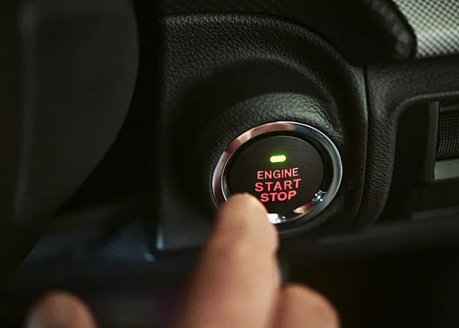 关闭一辆汽车引擎启动停止按钮即将被推动。...