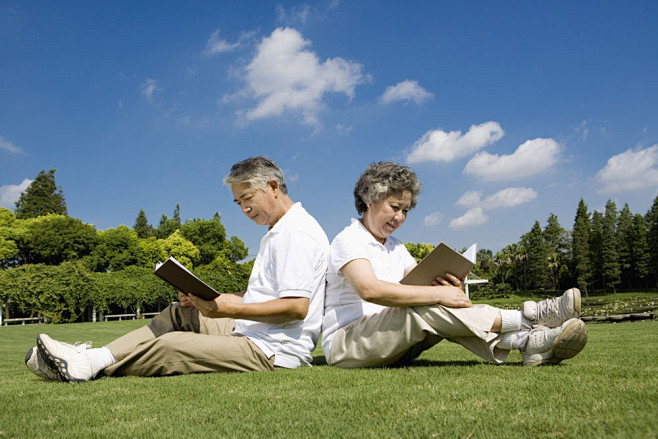 坐着草地上看书的老年人高清图片图片