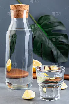 视错觉柠檬水扭曲透过玻璃，柠檬水或柠檬水，怪物的叶子在灰色的背景，垂直