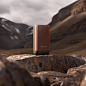 On the rocks of the mountain is a Sonos speaker, The background is a brown mountain rock