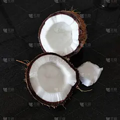 一个椰子被分成两部分。外壳硬，内肉嫩。黑色的背景