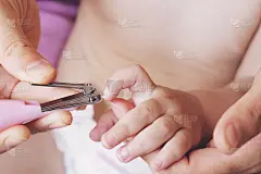 用手给宝宝剪指甲和指甲，妈妈用小剪刀把指甲剪干净，用爱心呵护。