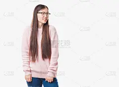 年轻的中国女子在孤立的背景下戴着眼镜看向一边，脸上带着微笑，表情自然。自信的笑。