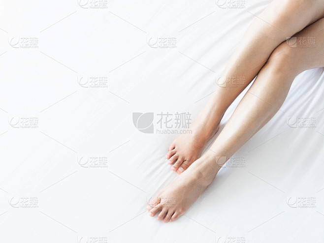 特写女人的腿在白色的床上，超轻的形式窗口...