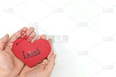 年轻男性手中拿着一个红色的心形标签，上面手写着“当地”字样。支持，爱，购买和活动的小型本地企业的理念