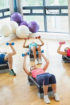 教练在健身班用哑铃做踏步有氧运动