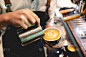专业的咖啡师用咖啡和牛奶制作拉花艺术，手持一杯拿铁，浓缩咖啡，卡布奇诺，在早餐时饮用