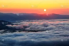 迷人的日出在高山，在底部有纹理的浓雾。太阳光从雾中反射出红色的光。一个吸引人的观点。