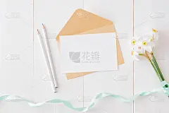 白色贺卡和信封与白色水仙花在白色木桌
