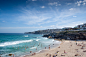 People having fun swimming in the blue ocean and relaxing on the beach shore on a summer day