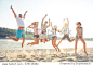 Group of happy young cheerful students jumping on the beach.