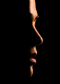 woman's face and lips coming out of shadows