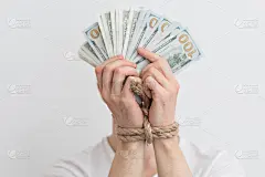 一个手里攥着美元的人，对钱的依赖，还款，信用欠款
