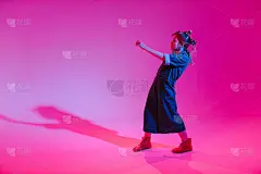 年轻时髦的女孩在彩色霓虹灯背景下在工作室跳舞。音乐dj海报设计。