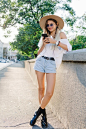 Free photo stylish romantic happy woman is posing on sun-drenched street. pretty girl is listening music in headphones.