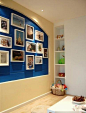 蓝色的墙面搭配上大大小小的相框，组成了照片背景墙，是地中海风格的。