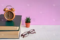 白色木桌上的书和眼镜是钟表和装饰品