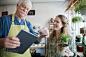 Shop owner using digital tablet credit card reader by Hero Images on 500px