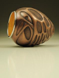 David Huang: This vessel was formed through traditional angle raising techniques and further embellished with chasing techniques. The approximate size is 4.25" x 3.75" x 3.75". It is made of copper, sterling silver, and 23-karat gold leaf. 