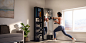 Woman exercises in front of a fitness mirror in living room