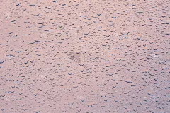 水滴雨在近距离的背景和纹理的粉红色汽车