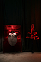 a red light shines in the middle of a dark room with a painting on it