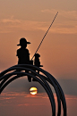 A boy with his dog and a fishing rod.