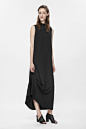 High-neck draped dress : This sleeveless dress is made from fluid, raw-cut crepe with an asymmetric drape detail on the hemline. An elongated shape, it has raised neckline, in-seam pockets and a hidden zip fastening along the back.