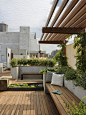 This is an example of a large traditional full sun rooftop landscape in New York with a water feature and decking.