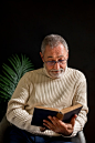 Surprised elderly man reading book