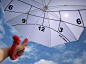 日本设计师kota nezu带来了一把时钟遮阳伞，它的上面从左到右标有6、9、12、3、6的数字，并划分区域，对应早上6点到晚上6点，根据太阳照在伞上的位置即可估算时间。伞把上面还带有一个指南针，方便寻找方向。