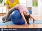 Cute child girl stretching on pilates fitness ball in gymStock Photo