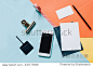 Creative flat lay style workspace desk with smartphone, blank envelope, sunglasses and masking tape on modern colorful background