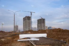 在建筑地盘铺设铺路板及路面时，用作防水。塔吊在蓝天的背景行动。