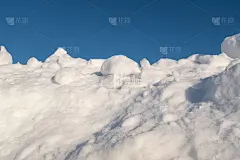 大雪过后，山上飘着蓬松的雪，周围是蓝色的天空。雪堆与蓝色的天空为海报，日历，邮政，屏幕保护程序，墙纸