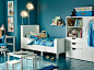 蓝色的儿童卧室内放着白色的可加长床、衣柜、桌子和书桌。