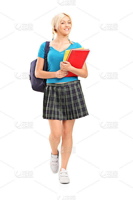 微笑的女学生走着，拿着书