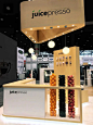 This may contain: the juicepresso stand at an event with fruit hanging from it's ceiling