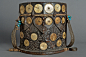 This may contain: an old wooden bucket with many circles and beads on the handle, sitting against a gray background