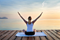 Young woman practising yoga by sea