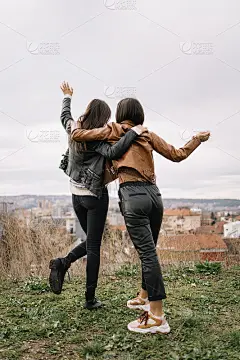 女孩们拥抱着，挥手致意