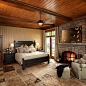 Bedroom - rustic master bedroom idea in Toronto with beige walls, a standard fireplace and a stone fireplace