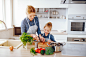 beautiful-mother-blue-shirt-apron-is-preparing-fresh-vegetable-salad-home