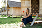 Beautiful girl sits near the bungalow and drinks coffee.