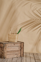 brown wicker basket on crate near wall