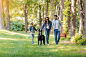 Premium Photo | Young interracial family with dog holding hands and walking  in sunny forest