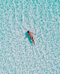 一名妇女的一张顶视图比基尼游泳的在她清楚的海洋水中的后面