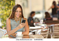 Girl texting on the smart phone in a restaurant terrace with an unfocused background
